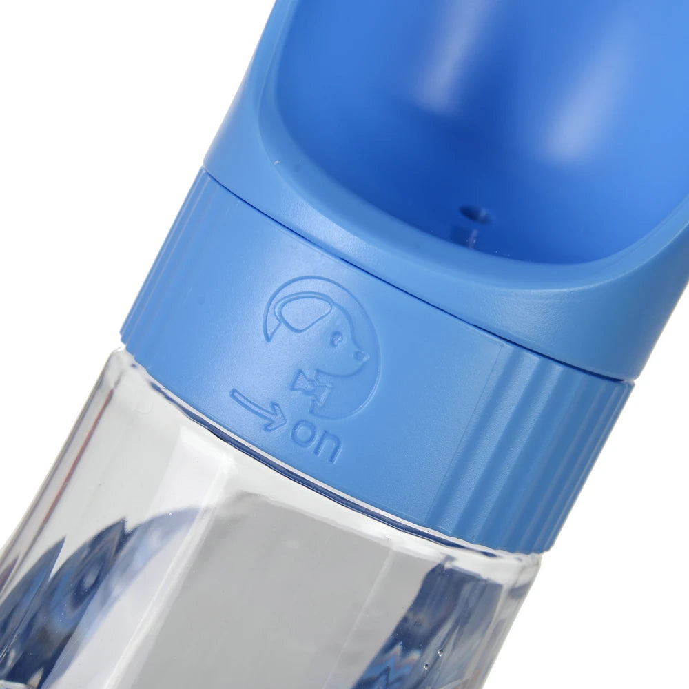 A close-up view of a blue portable pet water and food dispenser with an on switch symbol.