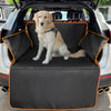 A golden retriever sits on a black waterproof dog car seat cover inside a vehicle.