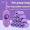 A purple pet poop bag dispenser and 20 rolls of biodegradable dog waste bags are displayed on a white surface.