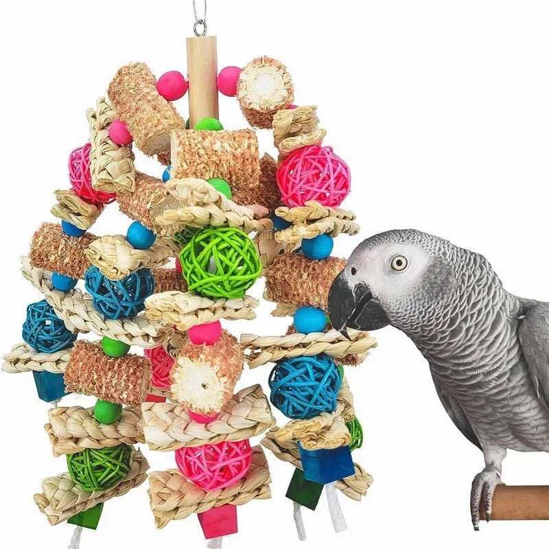Ein grauer Papagei interagiert mit einem Holzspielzeug aus geflochtenen Naturfasern und bunten Holzstücken.