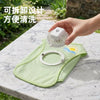 A hand holds a light green cooling dog vest with a built-in fan on a marble surface.