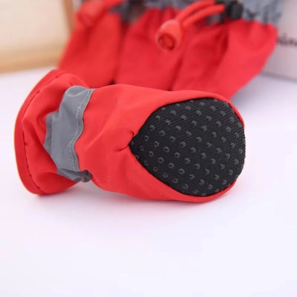 A close-up of a red and gray cozy anti-slip dog bootie with a black reflective grip.