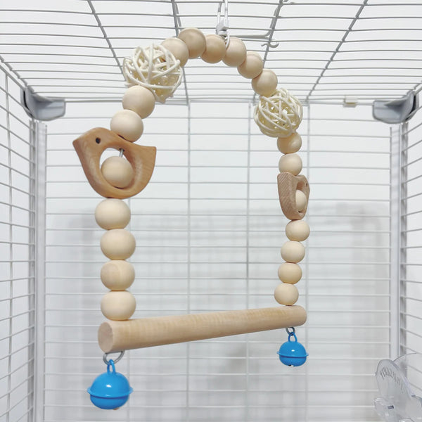 A decorative parrot swing toy made of light wood beads suspended from a wire cage.
