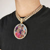 A gold-toned chain necklace features a pendant depicting several children in a photo.