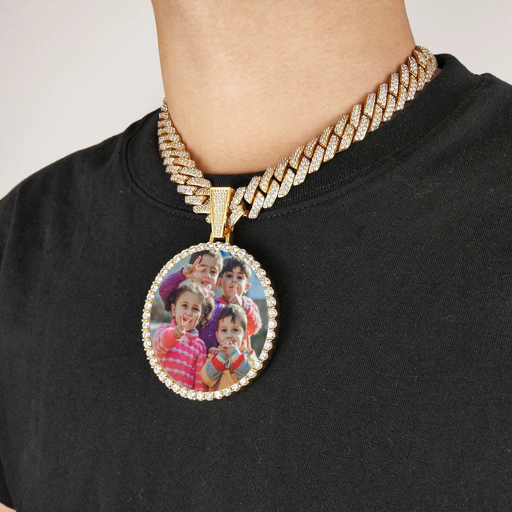 A gold-toned chain necklace features a pendant depicting several children in a photo.