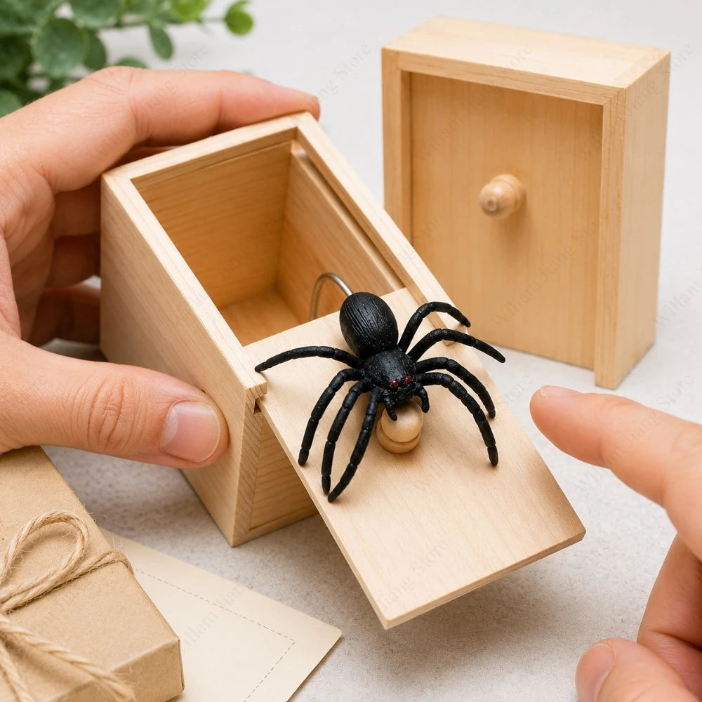 A hand is opening a wooden box to reveal a black spider inside.