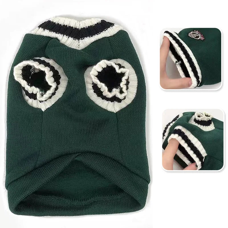 A dark green knit vest for a small dog featuring black and white striped trim on the neckline and sleeves.