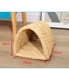 A natural straw woven mat shaped like a burrow for small rodents, shown on a wooden surface.
