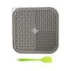 Gray silicone licking mat for dogs and cats with suction cups and a lime green silicone spoon