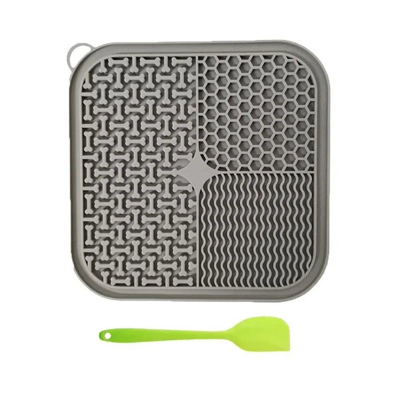 Gray silicone licking mat for dogs and cats with suction cups and a lime green silicone spoon