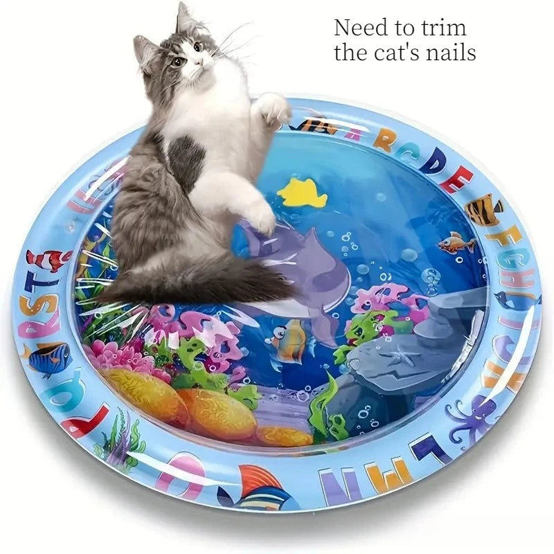 A playful kitten is shown on a blue mat featuring an ocean fish design for cat nail trimming.