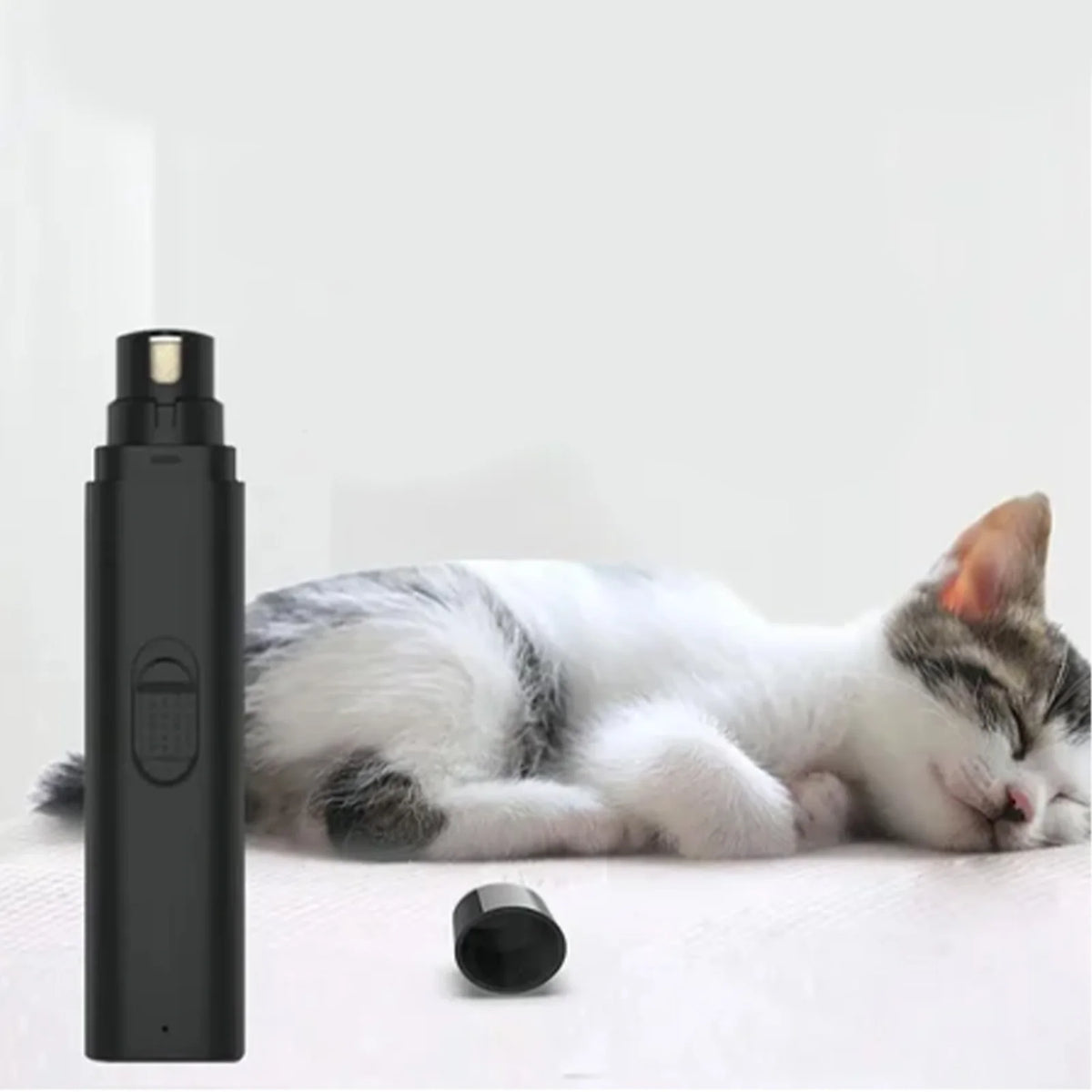 Schwarzer, wiederaufladbarer Nagelhaut-Grät슈 für Haustiere neben einer schlafenden weißen und grauen Katze.