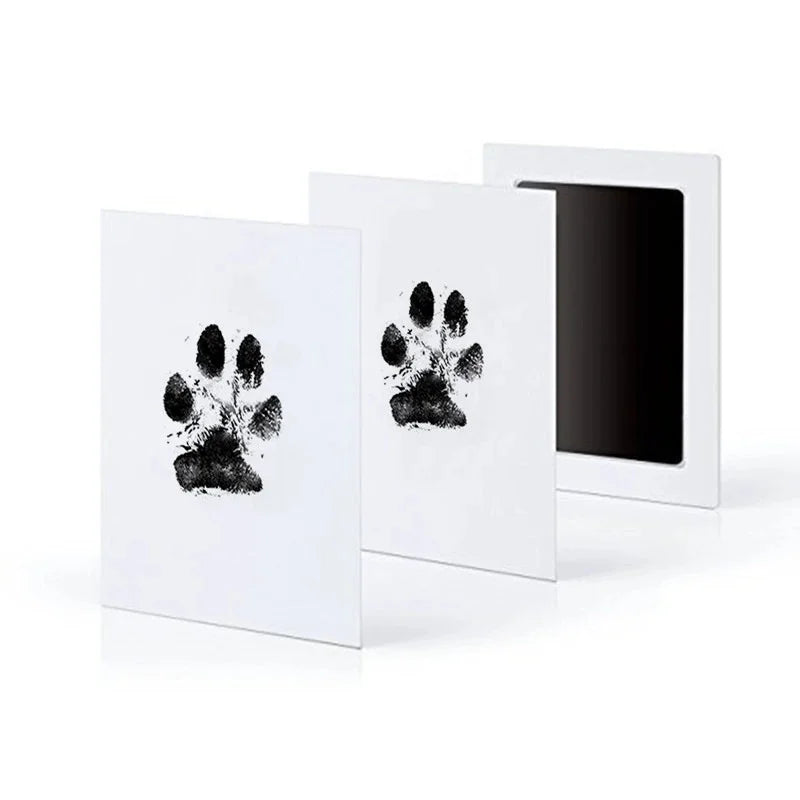 A set of three white framed prints featuring black paw print designs for pet keepsakes.