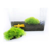 Vibrant artificial green plants used as decor in a glass aquarium tank.