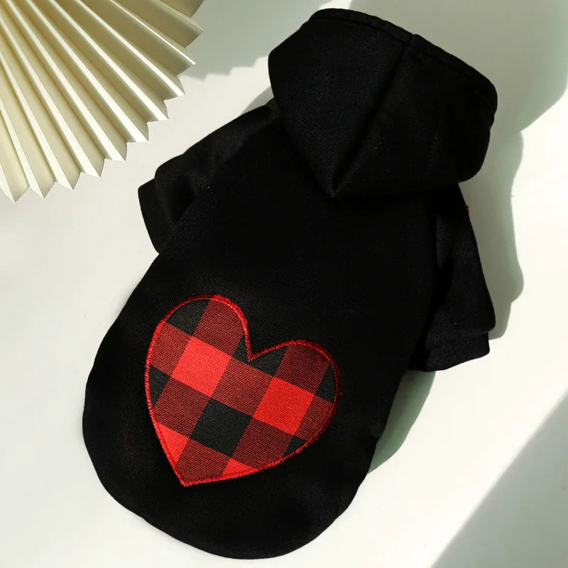 Black reversible plaid winter pet jacket for dogs lying on a white surface.