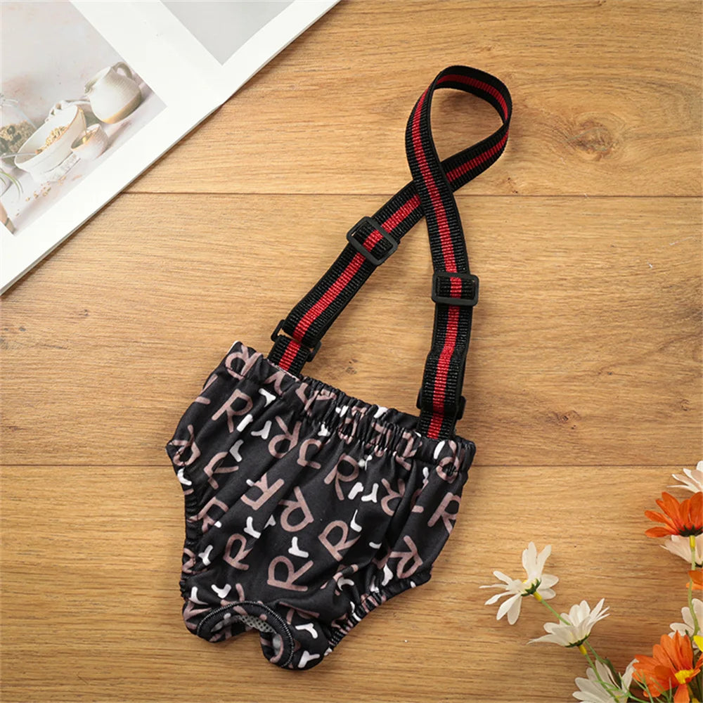 Schwarze wiederverwendbare Hunde-Physiologie-Shorts mit rotem Zierrand auf einer Holzoberfläche.