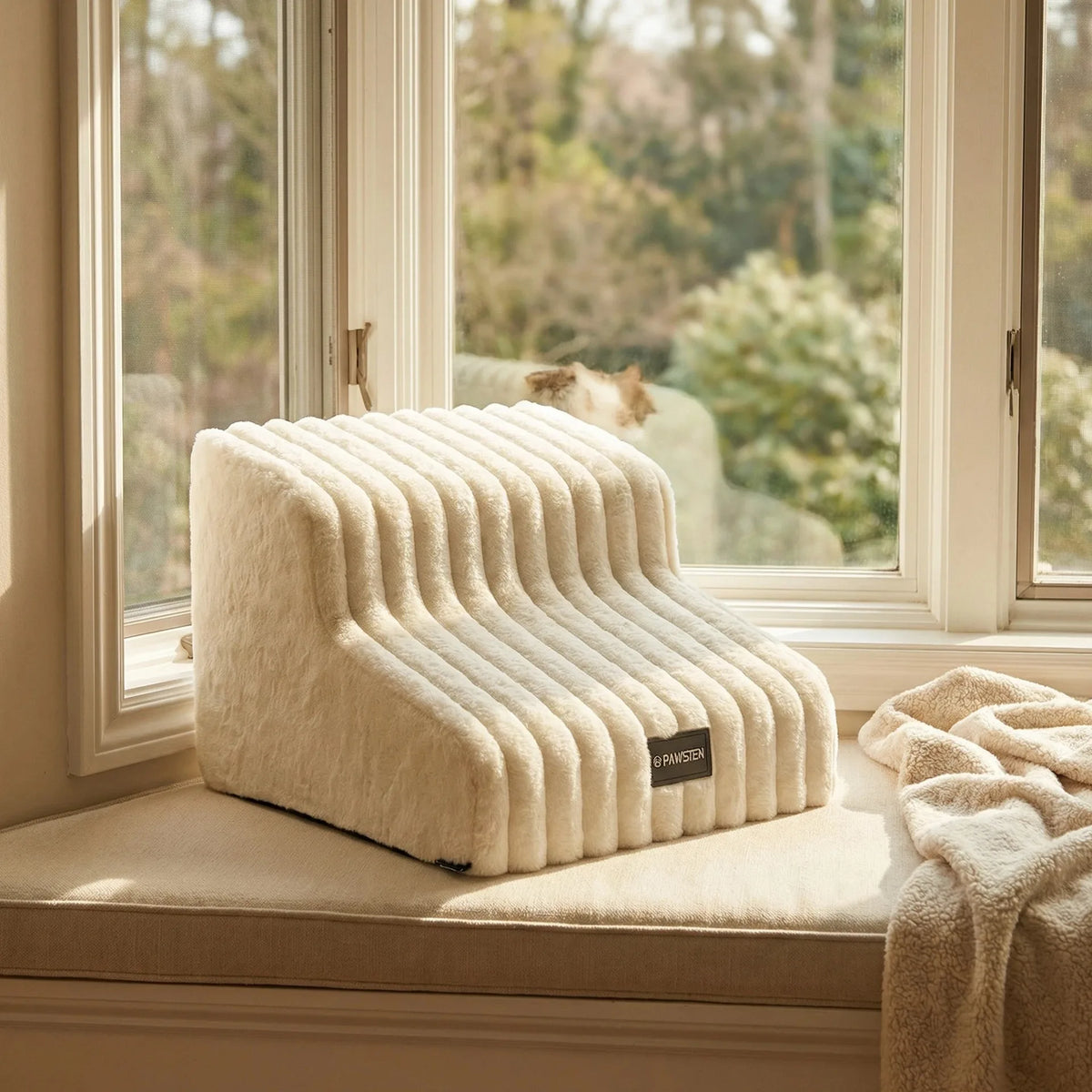 A beige pet safety climbing stairs product resting on a windowsill with blurred greenery outside.