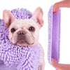 A light-colored dog's head is resting on a purple chenille pet bath towel.