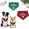 A black and white dog wearing a green Christmas triangle scarf bandana with a festive design.