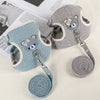 A gray padded rabbit harness and leash set with a matching rolled-up strap shown on a white background.