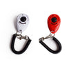 Une paire de clickers d'entraînement pour animaux, un blanc et un rouge, fixés à des bracelets de poignet noirs ajustables.
