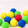 Eine Sammlung leuchtend bunter, flauschiger Spielbälle in Gelb, Blau, Grün und Rot.