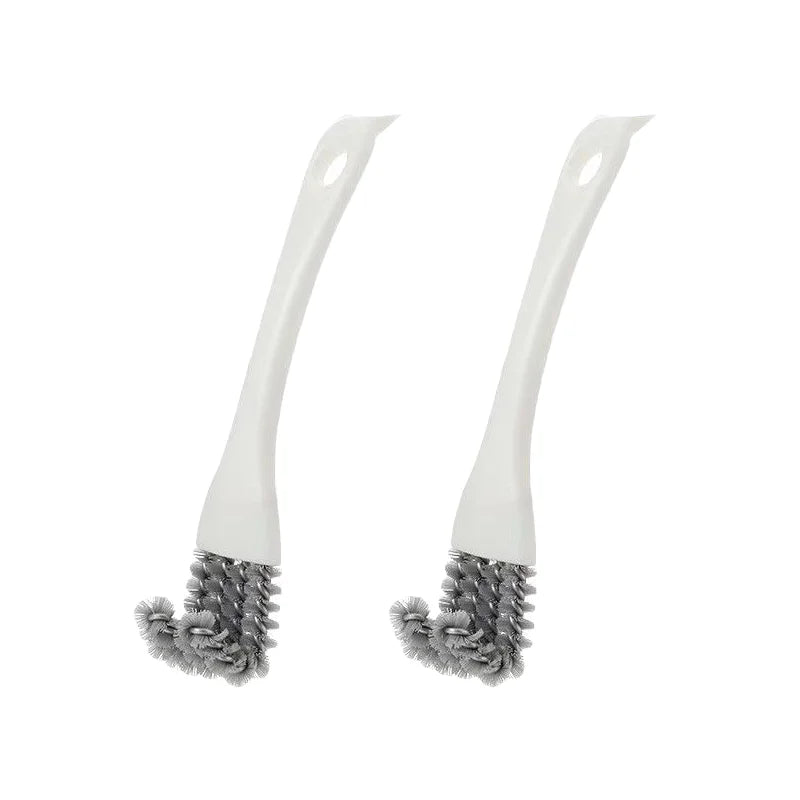 Une paire de brosses à nettoyer blanches avec des poils gris pour le nettoyage des cages d'animaux.
