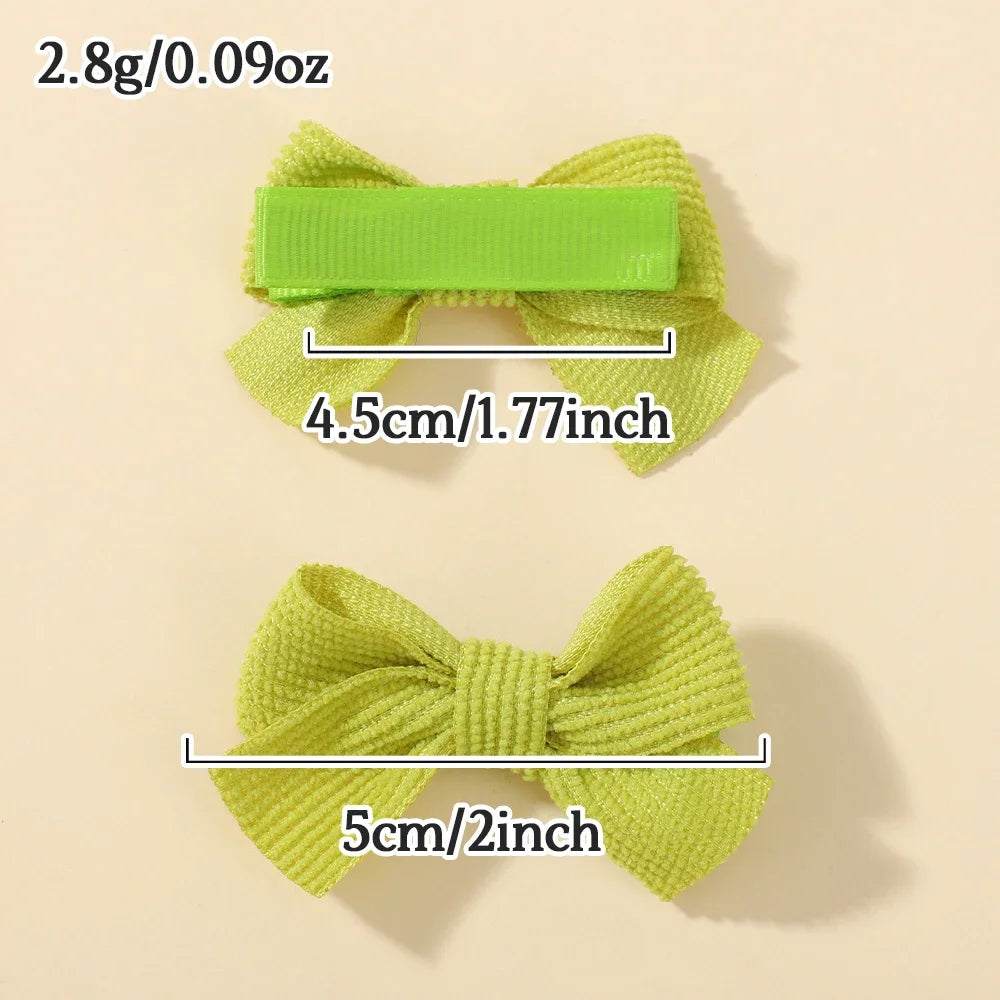 Une pince à cheveux en ruban vert lime, montrant sa taille et son matériau avec une règle.