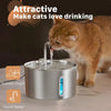 Un chaton orange boit de l'eau d'une fontaine à eau en acier inoxydable avec un bec.