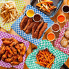 A spread of fried food, including french fries and chicken strips, served on colorful wrapping paper.