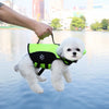 A white dog wearing a neon green life jacket is being held by a person above water.