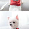Ein weißer Hund in einem rot-weißen Chicago-inspirierten Pet-Westen und Trikotanzug.