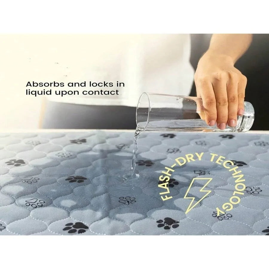A hand pours liquid onto a gray quilted pad, demonstrating the flash-dry technology of washable reusable dog urine pads.