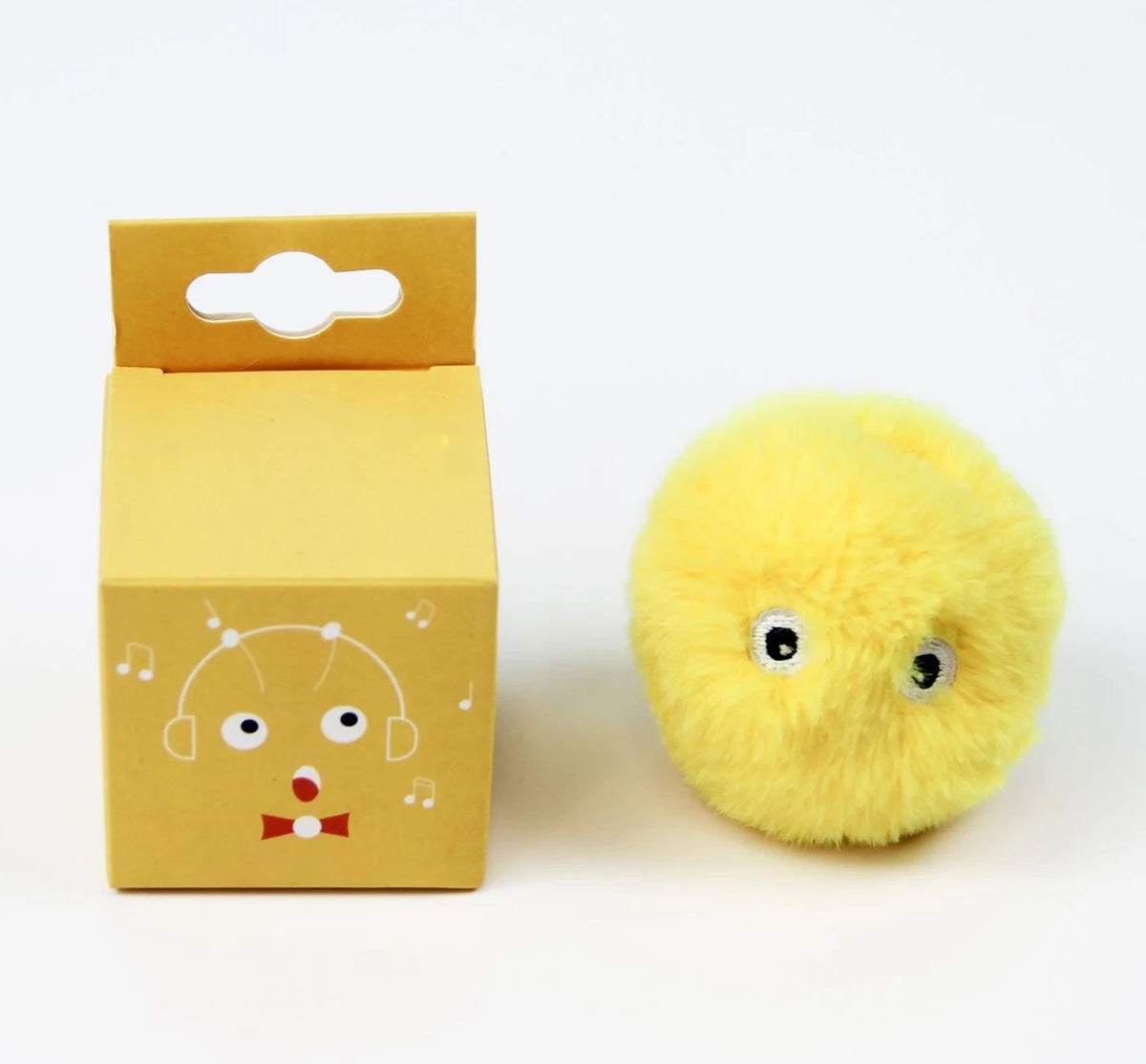 A yellow cardboard box with a cutout, next to a round, fluffy yellow cat toy.