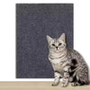 Eine graue Tabby-Katze sitzt auf einer dunkelblauen strukturierten Matte.