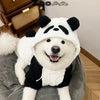 A white dog plush toy with a black panda face design wearing a black coat.