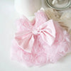 Vestidos para mascotas florales rosas con tela fruncida y un lazo, mostrados sobre una superficie blanca.