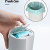 A hand is shown inserting a reusable pet litter scoop with a waste bag into a white container.