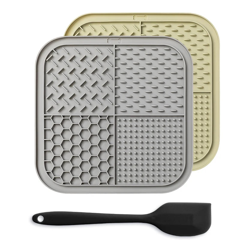 A gray silicone lick mat for pets is shown next to a black silicone spoon.