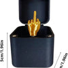 A black wooden box with a lid open, revealing a golden hand figure.