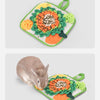 A green mat with an orange flower design and a green handle, featuring a small rabbit.