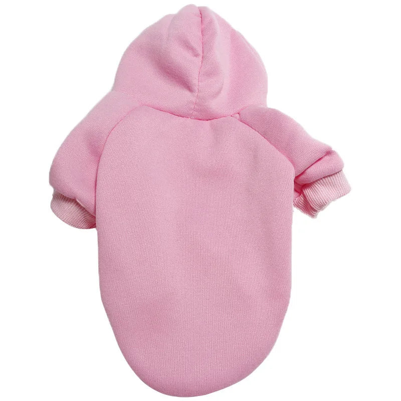 A pink cozy hoodie for a dog, featuring a hood and long sleeves.