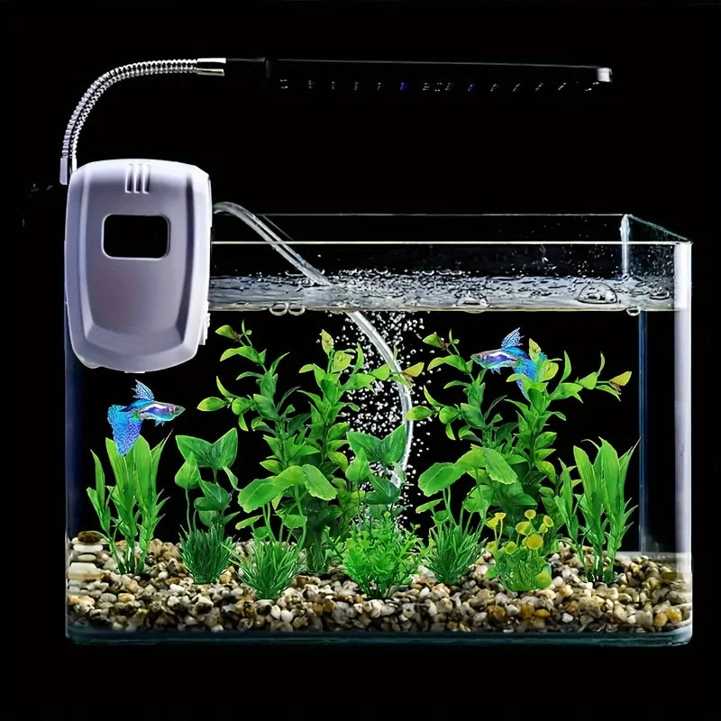 A clear glass aquarium containing vibrant green artificial water grass plants and a white air pump.