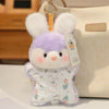 A small purple and white cartoon animal bean bag plush toy with large ears and a pink nose is displayed next to a beige canva