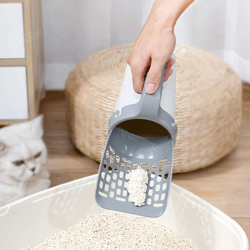 A hand is pouring white cat litter into a gray heavy duty litter shovel, with a large bowl of litter nearby.
