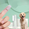 A hand holds a silicone pet toothbrush next to a golden retriever dog.