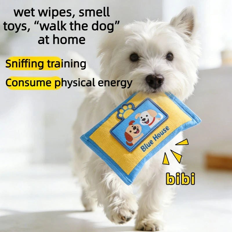 A white dog is sniffing a blue fabric puzzle toy designed for training and physical exercise.