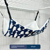 Eine kleine, zweckentfremdete Hammock, die wie eine Wal geformt ist, hängt in einem Drahtgitter.