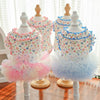A display of floral princess pet dresses for dogs and cats in various colors like pink and blue.