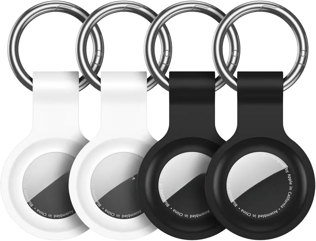 A silicone airtag protective cover with a keychain is shown in white and black.